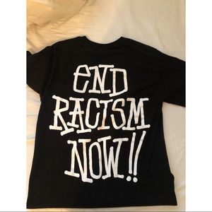 A black stüssy t-shirt with “End Racism Now!”